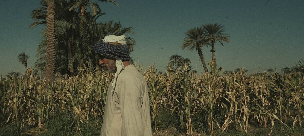 Picture showing man walking in front of a field